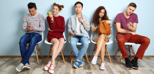 Students sitting in a line waiting to be called.