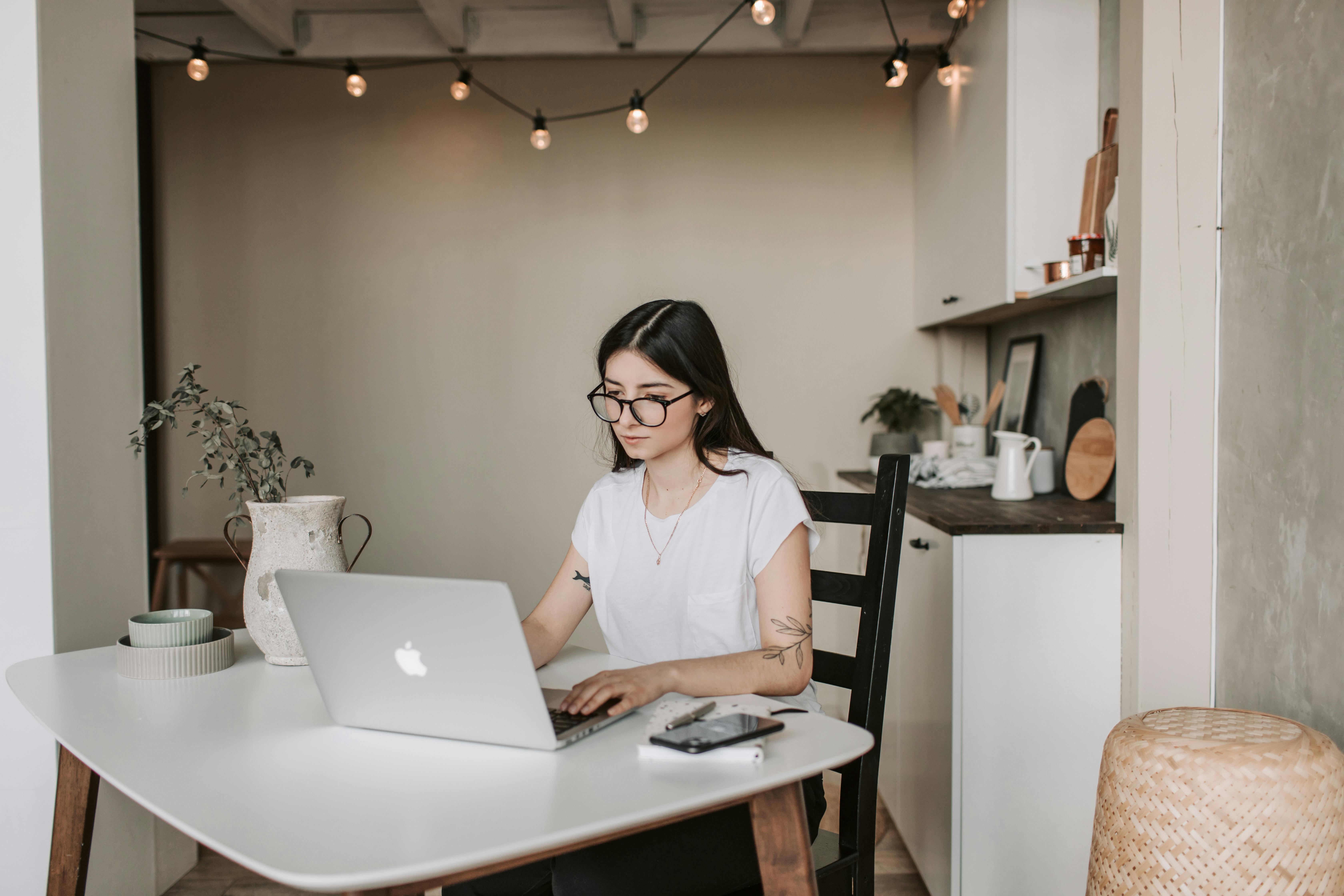 A teenage girl working at a laptop.